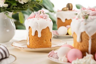 selective focus of Easter cakes with white glaze and meringue on table clipart