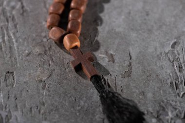 wooden rosary with cross on grey textured surface clipart