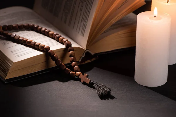 Священная Библия Четками Черном Темном Фоне Горящими Свечами — стоковое фото