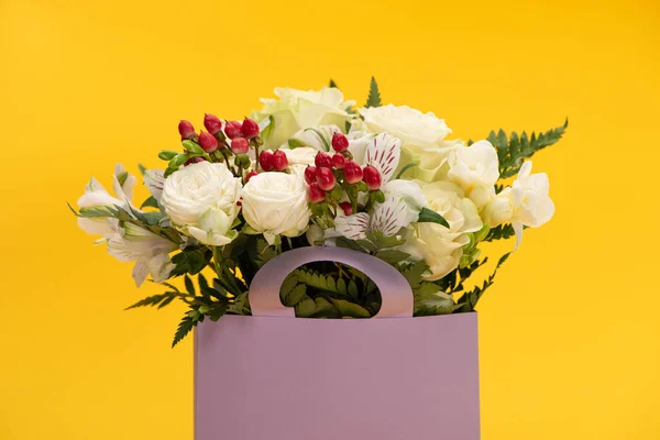 在紫色纸袋中的春天鲜花花束 用黄色隔开 — 图库照片