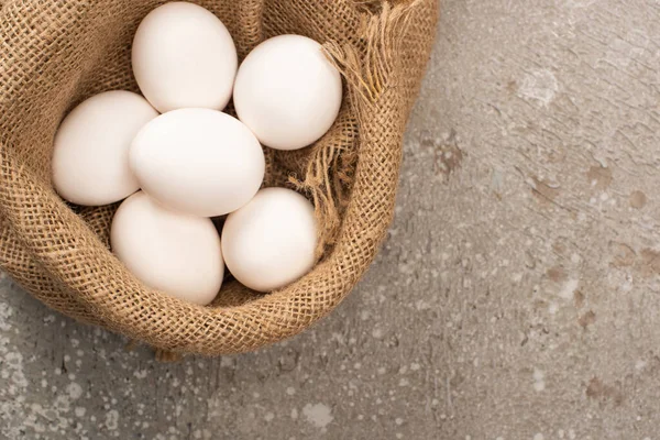 Vista Superior Ovos Brancos Pano Saco Sobre Fundo Concreto Cinza — Fotografia de Stock
