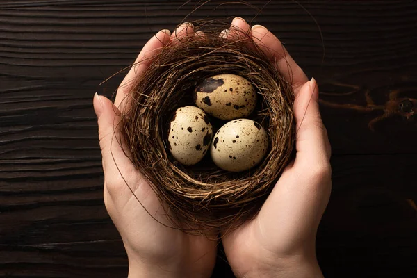 Gedeeltelijk Uitzicht Vrouw Met Kwarteleitjes Donkere Houten Achtergrond — Stockfoto