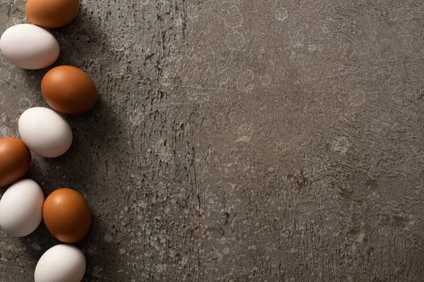 Vista Superior Ovos Galinha Marrom Branco Sobre Fundo Texturizado Cinza — Fotografia de Stock