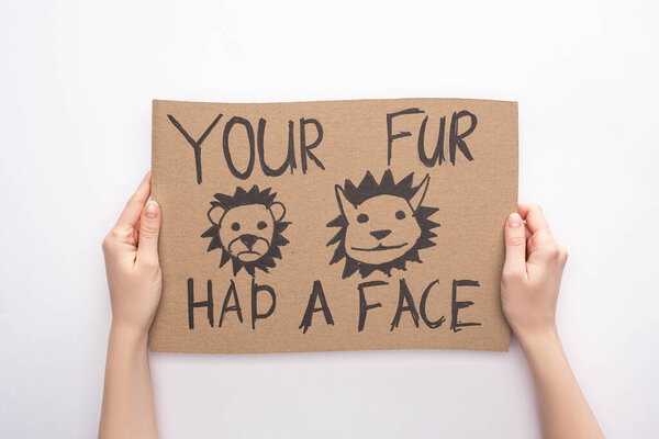 partial view of woman holding cardboard sign with your fur had a face inscription on white background