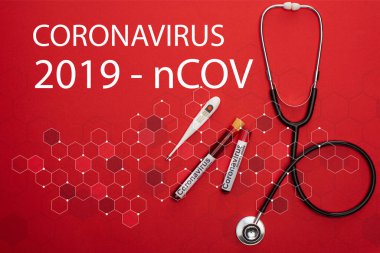 Top view of stethoscope, thermometer and test tubes with blood samples and coronavirus 2019-ncov lettering on red background clipart