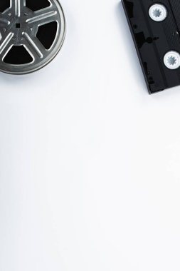 top view of old VHS cassette and film reel on white background clipart