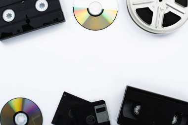 CD disklerin üst görünümü, VHS kasetler, film makarası ve beyaz arkaplanda disketler