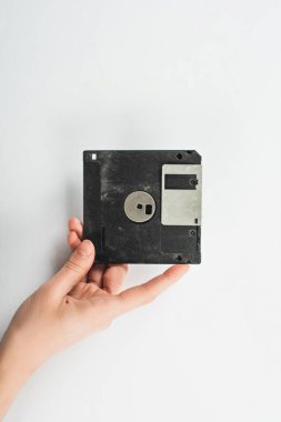 Siyah disketi beyaz arka planda tutan adamın kısmi görünümü
