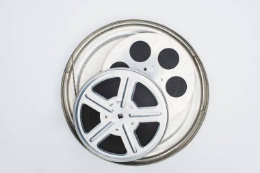 top view of film reels with film strip in tin case on white background clipart