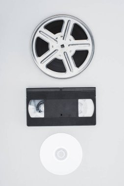 top view of film reel, VHS cassette and CD disc on white background clipart