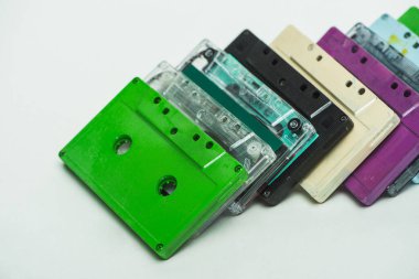 green, turquoise, purple and black retro cassettes on white background clipart