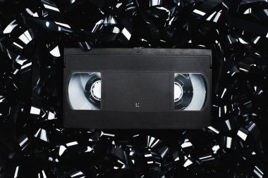 Film şeridi üzerindeki siyah VHS kasetinin üst görünümü