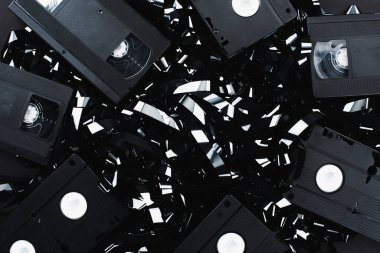 Siyah film şeridi üzerindeki VHS kasetlerinin üst görünümü