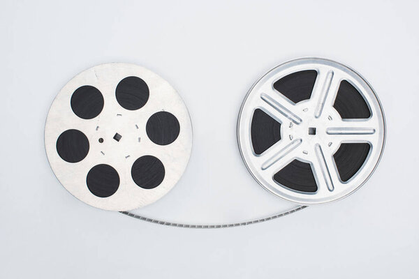 top view of movie reels with film strip on white background