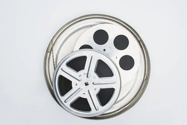 stock image top view of film reels with film strip in tin case on white background