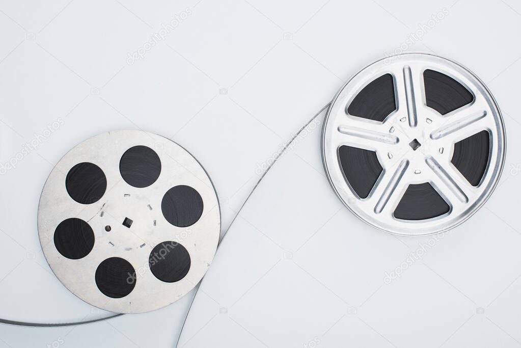 top view of film reels and film strip on white background
