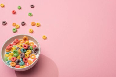 bright colorful breakfast cereal with milk in bowl on pink background clipart