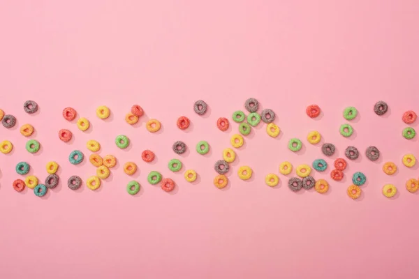 色彩艳丽的早餐麦片散布在粉色背景的顶部视图 — 图库照片