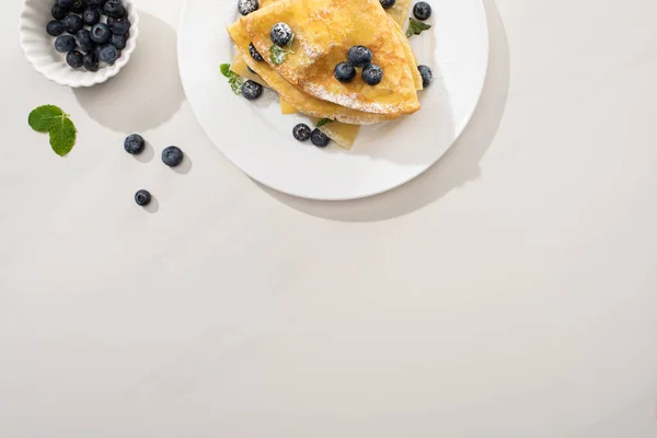 蓝莓和薄荷糖放在盘子里 灰蒙蒙的背景的美味软糖的顶部视图 — 图库照片