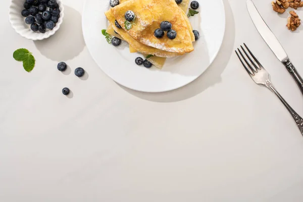 Top View Tasty Crepes Blueberries Mint Plate Walnuts Cutlery Grey — Stock Photo, Image