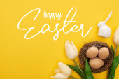 felső nézet tulipán és csirke tojás fészekben közel húsvéti nyuszi színes sárga háttér boldog húsvéti illusztráció
