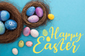 Draufsicht auf bunte Ostereier in Nestern auf blauem Hintergrund mit frohen Ostern Illustration