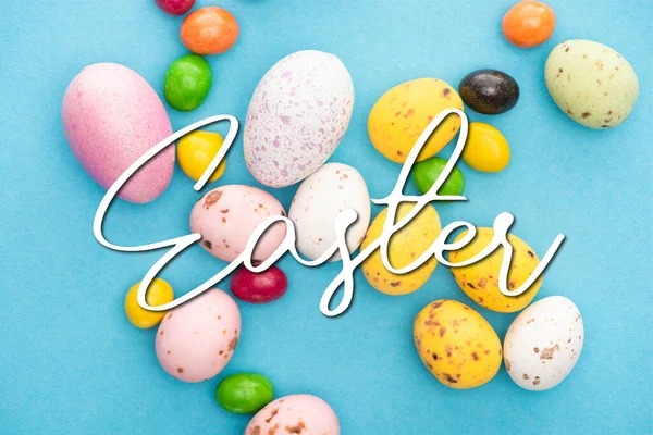 鮮やかな色鮮やかなお菓子とイースターの卵のトップビューを背景に イースターのイラスト — ストック写真