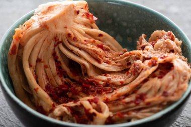 Çimento yüzeyinde lezzetli kimchi lahanası olan kaseyi kapat.
