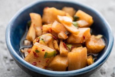 close up of tasty daikon radish kimchi in bowl clipart