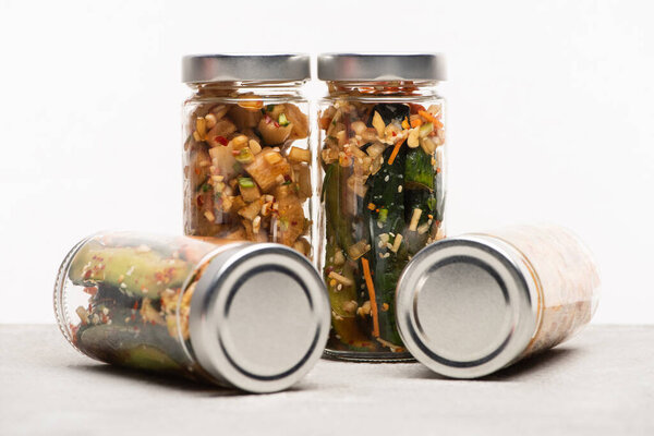 delicious cucumber and daikon radish kimchi in glass jars isolated on white