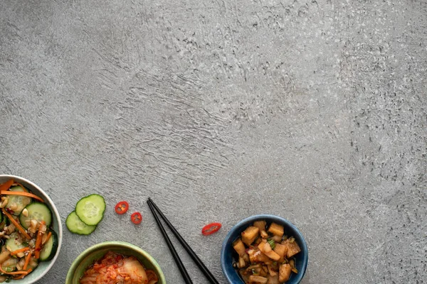 Top View Bowls Delicious Kimchi Sliced Cucumber Chopsticks Concrete Surface — Stock Photo, Image
