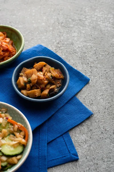 Schalen Mit Leckeren Kimchi Auf Blauem Tuch Auf Betonoberfläche — Stockfoto