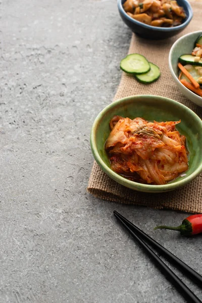 Bowls Tasty Kimchi Sackcloth Chopsticks Concrete Surface — Stock Photo, Image