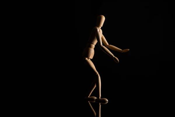 黒の背景に手を伸ばし木製の人形 — ストック写真