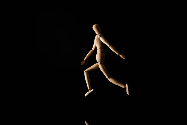 黒の上を走る木製の人形 — ストック写真