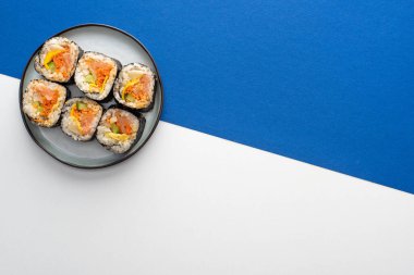 Beyaz ve mavi renkli gimbap ile tabağın üst görüntüsü 