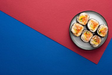 Kırmızı ve mavi renkli gimbap ile tabağın üst görüntüsü 