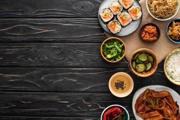 Bovenaanzicht Van Smakelijke Koreaanse Bijgerechten Bij Gimbap Sesamolie Houten Ondergrond — Stockfoto