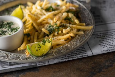 Patates kızartmasının yanında dilimlenmiş limonun seçici odağı. 