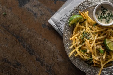 Patates kızartması ve mermer yüzeyde dilimlenmiş limon manzarası. 