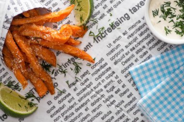 Çıtır patates kızartması, dilimlenmiş limon, pamuk peçete ve sarımsak sosu. 