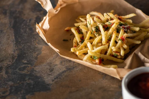 Tasty french fries on baking paper near ketchup on marble surface — Stock Image Tasty French Fries Baking Paper Ketchup Marble Surface Royalty Free Stock Photos