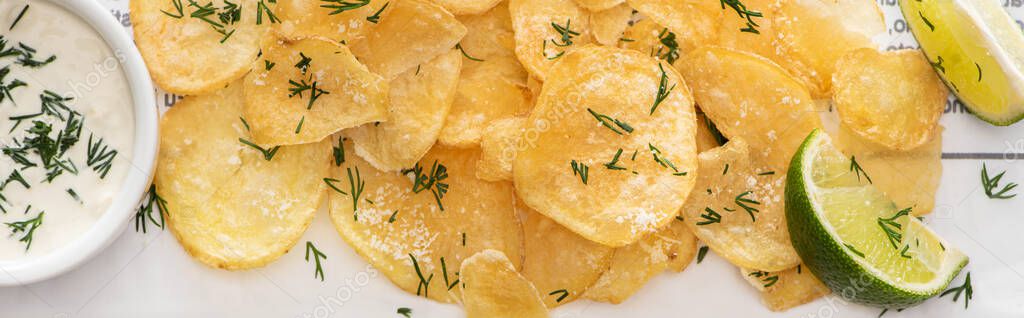 Panoramic shot of crunchy potato chips with salt near sliced lime and garlic sauce on white — Stock Image Panoramic Shot Crunchy Potato Chips Salt Sliced Lime Garlic Sauce Stock Picture