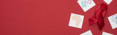horní pohled na červené informační pomůcky stuha a papírové karty na červeném pozadí, panoramatický záběr