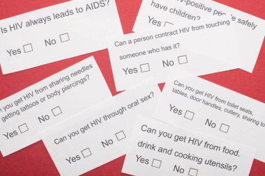 Kırmızı zemin üzerinde HIV anketi olan kağıt kartların üst görünümü