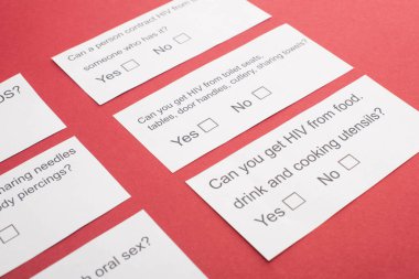 paper cards with HIV questionnaire on red background