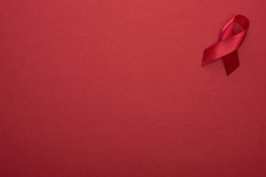 top view of red awareness aids ribbon on red background clipart