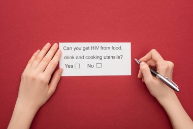 cropped view of woman answering HIV questionnaire on red background clipart