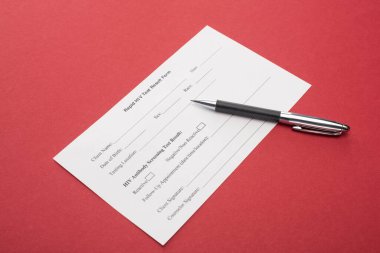Kırmızı arka planda kalemi olan hızlı HIV test sonuçları formu