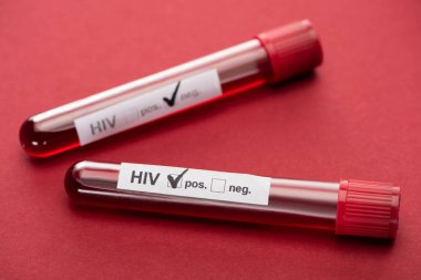 Kırmızı zemin üzerinde negatif ve pozitif HIV kan örneklerinin seçici odak noktası